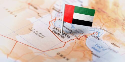 The flag of United Arab Emirates pinned on the map. Horizontal orientation. Macro photography.
